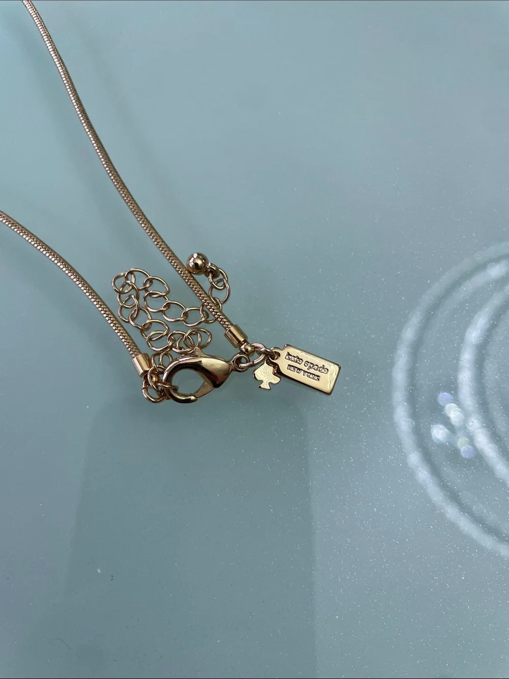 Kate Spade New York Pendant in gold with pearls long chain.